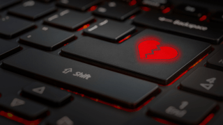 Eine Tastatur in der Nahaufnahme. Anstelle der Entertaste befindet sich das Symbol eines gebrochenen Herzens