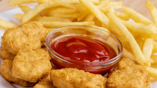 Ein Teller mit Nuggets und Pommes mit Ketchup