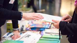 Besucherin an einem Infostand wird beraten