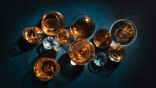 Blick von oben auf verschieden Schnapssorten in Gläsern auf einem Tisch.