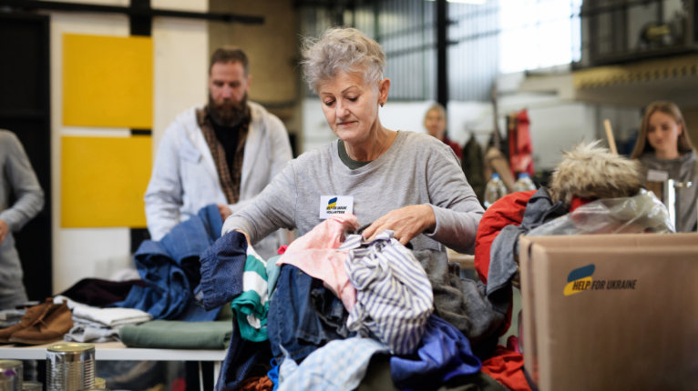 Mehrere Personen packen Hilfspakete mit der Aufschrift "Help for Ukraine".